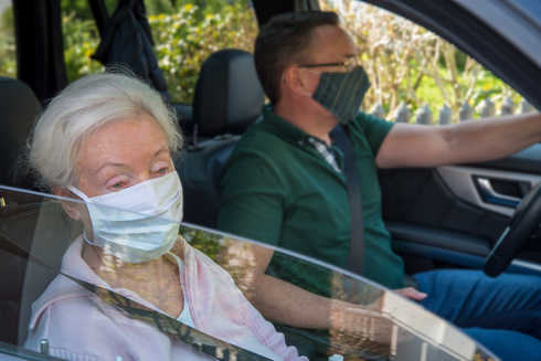Une femme et un homme dans une voiture portant un masque chirurgical