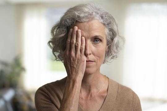 Une dame avec la main droite devant l'oeil droit